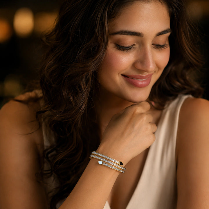 Gold teardrop crystal layered kada on a dark jewellery studio display