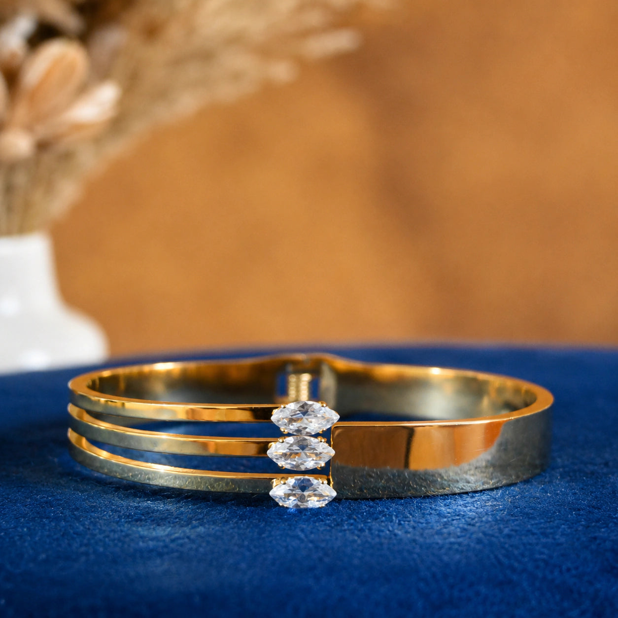 Angled view of the gold triple-bar crystal kada