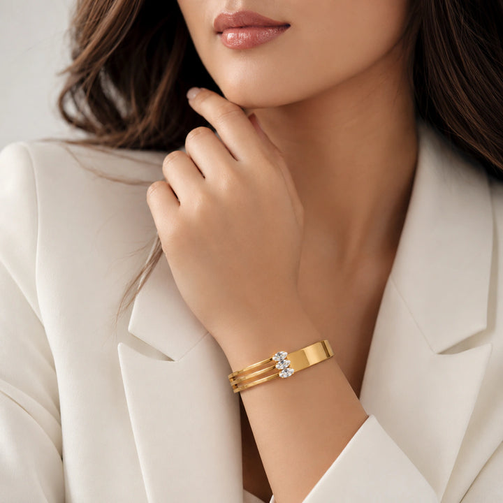Gold triple-bar crystal kada on a dark jewellery studio display