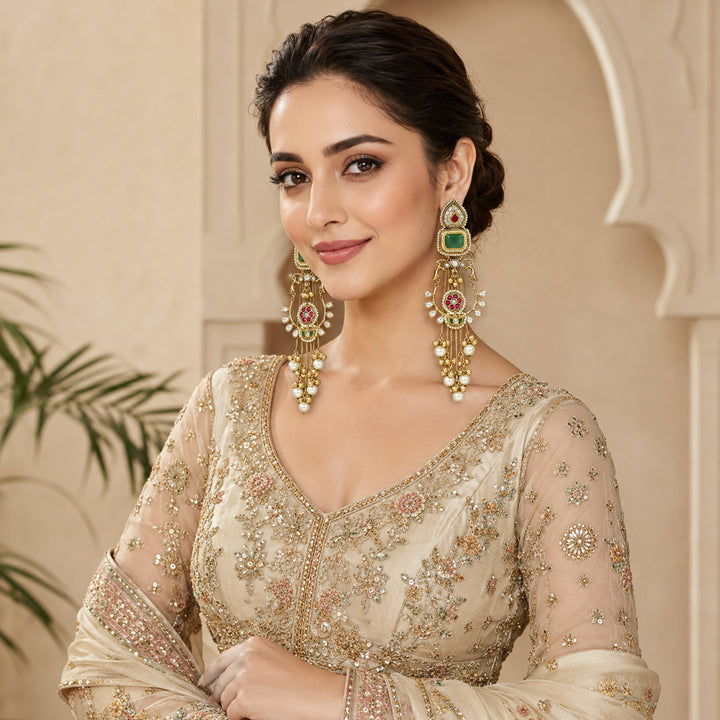 Close-up of green stones, pearl-style beads and layered gold-tone chandelier detailing