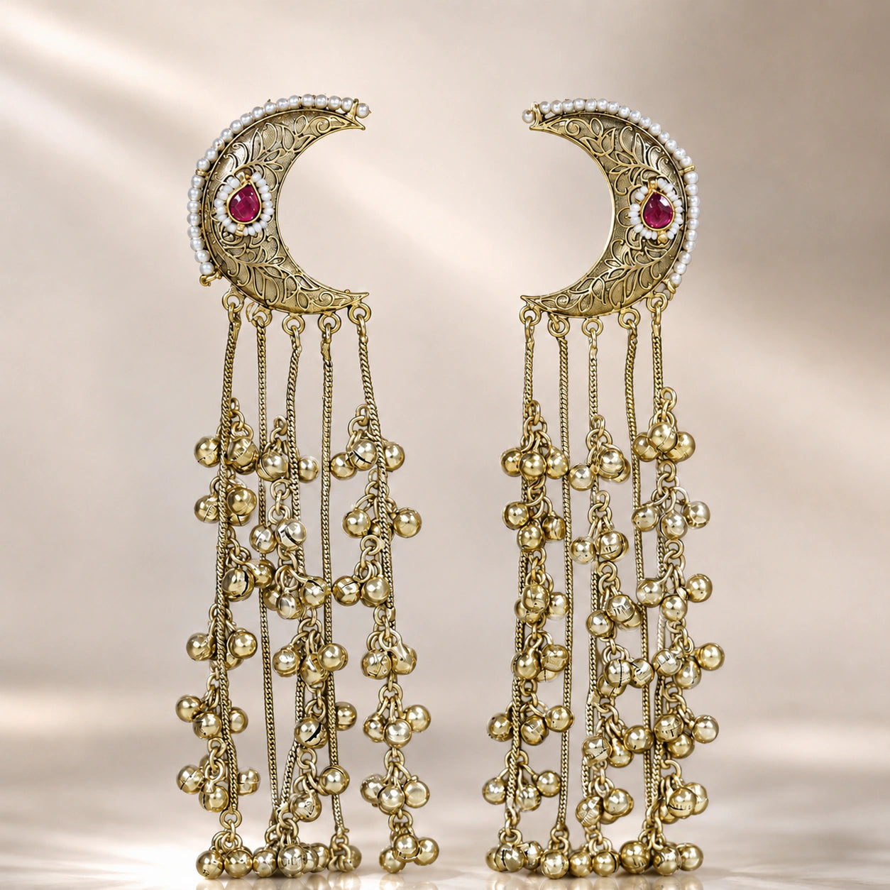 Angled view of gold-tone Kundan-style chandbali earrings with hanging details