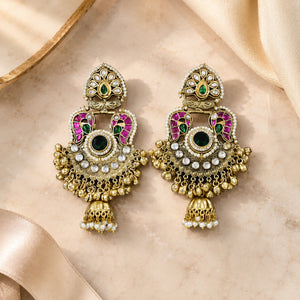 Angled view of gold-tone Kundan-style jhumka earrings with pearl-style drops