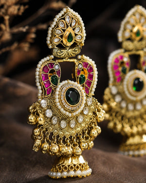 Gold-tone Kundan-style Meenakari pearl jhumka earrings worn by a model