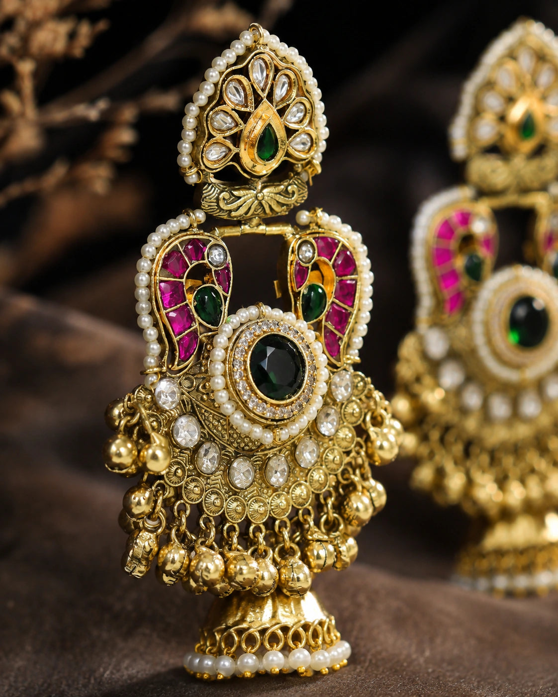 Gold-tone Kundan-style Meenakari pearl jhumka earrings worn by a model
