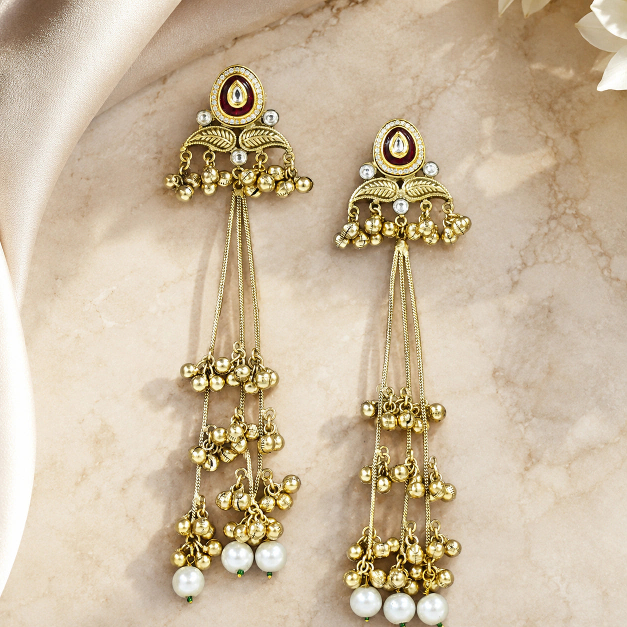 Gold-tone Kundan pearl chandelier statement earrings worn by a model