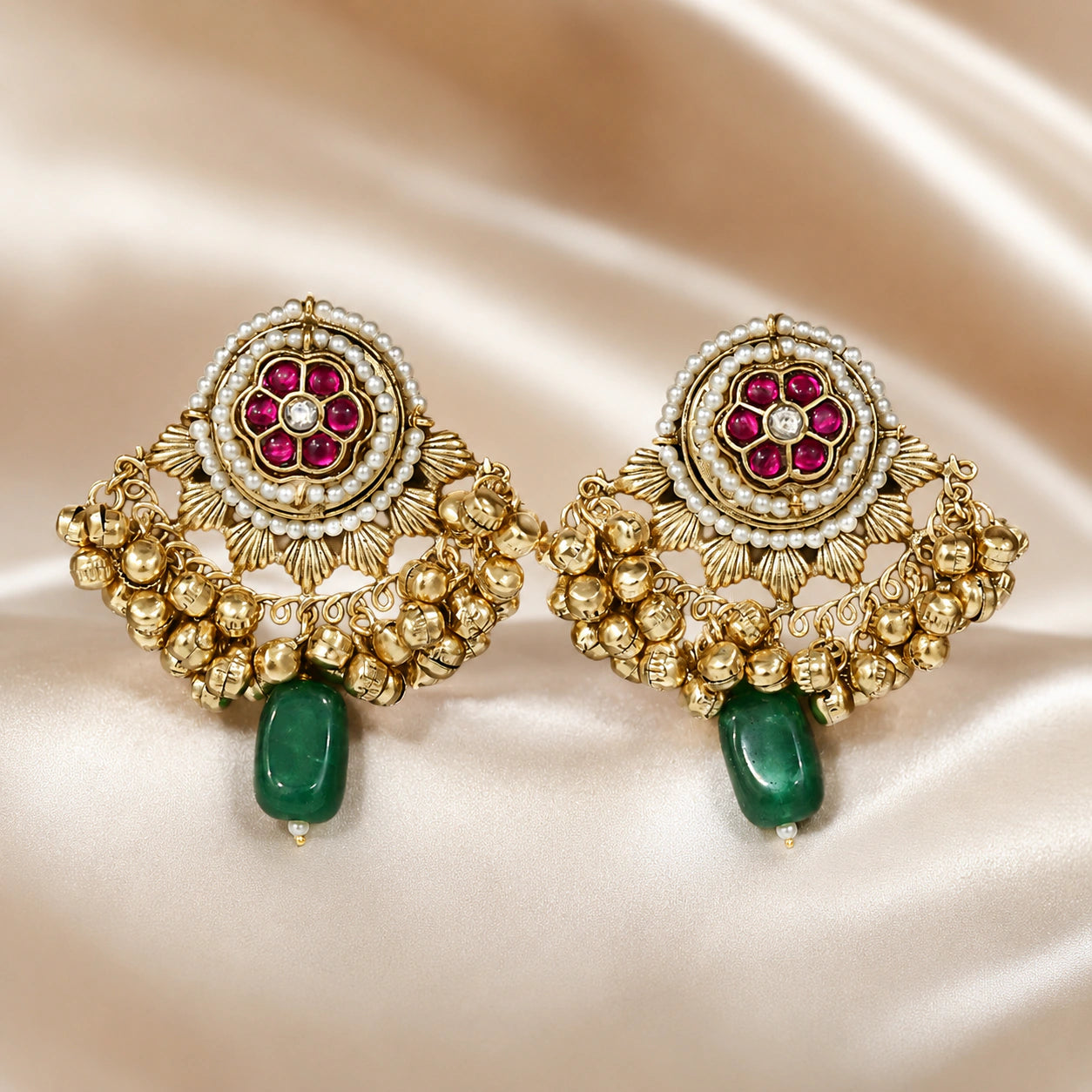 Angled view of gold-tone Kundan pearl jhumka earrings with layered hanging details