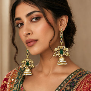 Gold-tone Kundan pearl jhumka earrings styled in an elegant jewellery flat lay