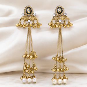 Angled view of gold-tone Kundan-style earrings with pearl-style tassel drops