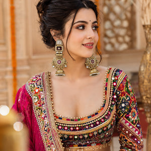 Long gold-tone maroon chandbali statement earrings worn by a model