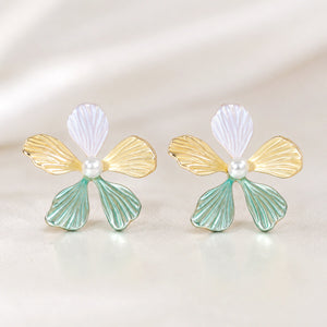 Multicolour floral pearl drop earrings on a dark jewellery studio display