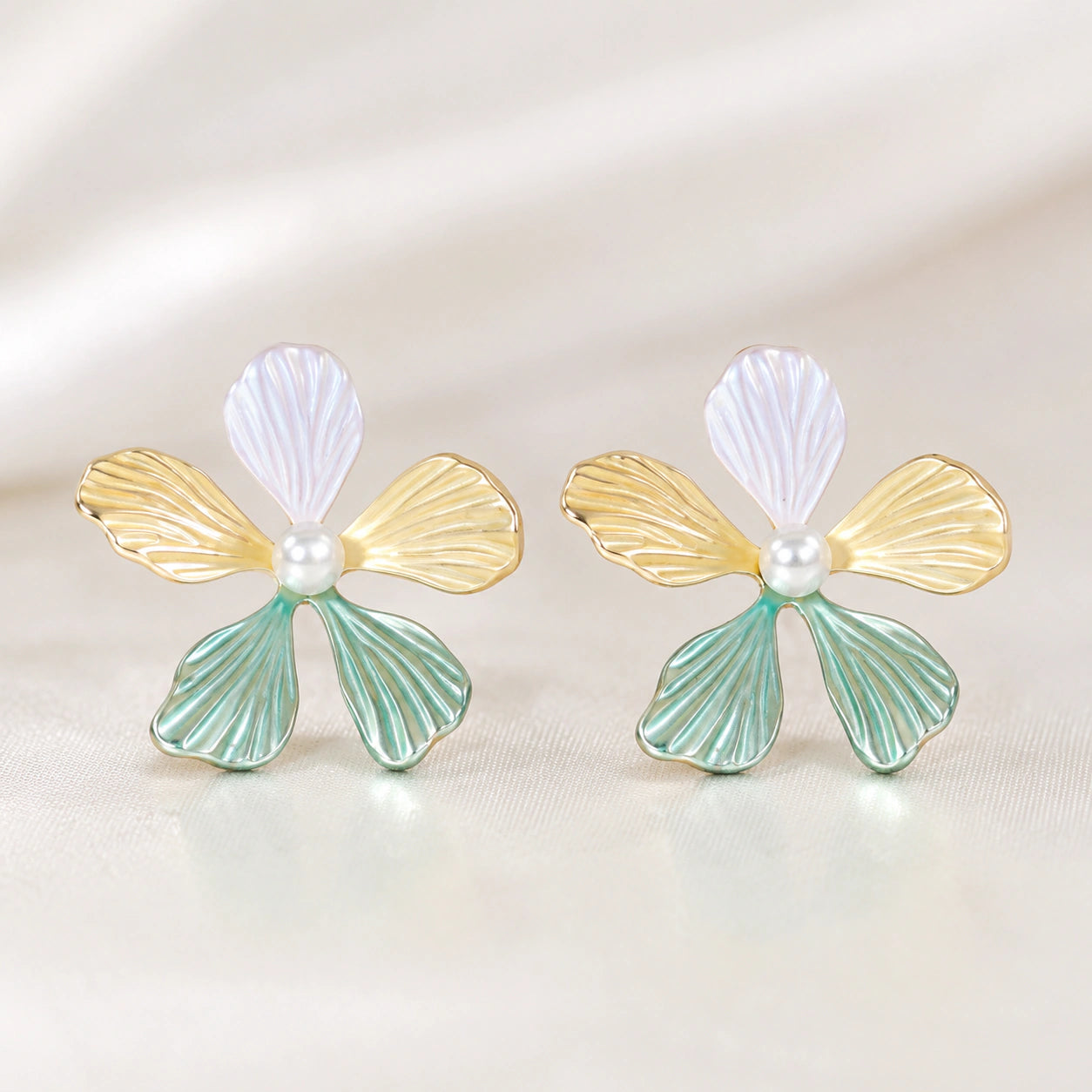 Multicolour floral pearl drop earrings on a dark jewellery studio display
