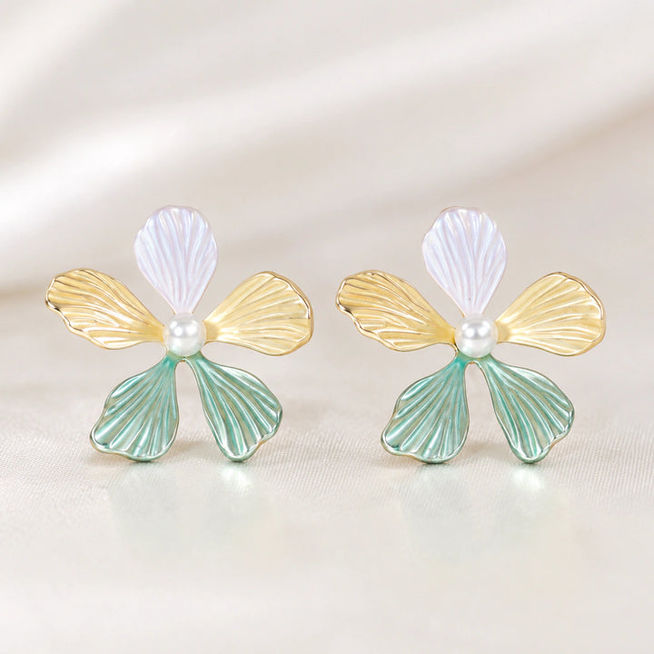 Multicolour floral pearl drop earrings on a dark jewellery studio display
