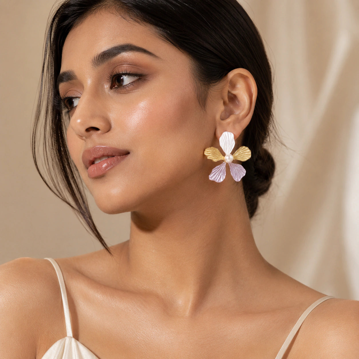 Lavender floral pearl drop earrings on a dark jewellery studio display