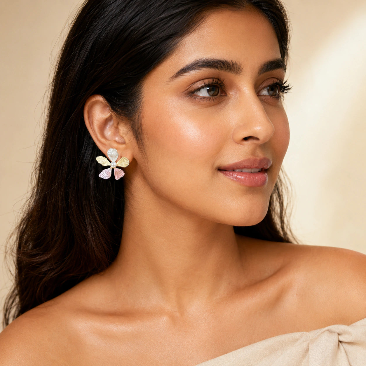 Angled view of multicolour pink floral pearl-style earrings