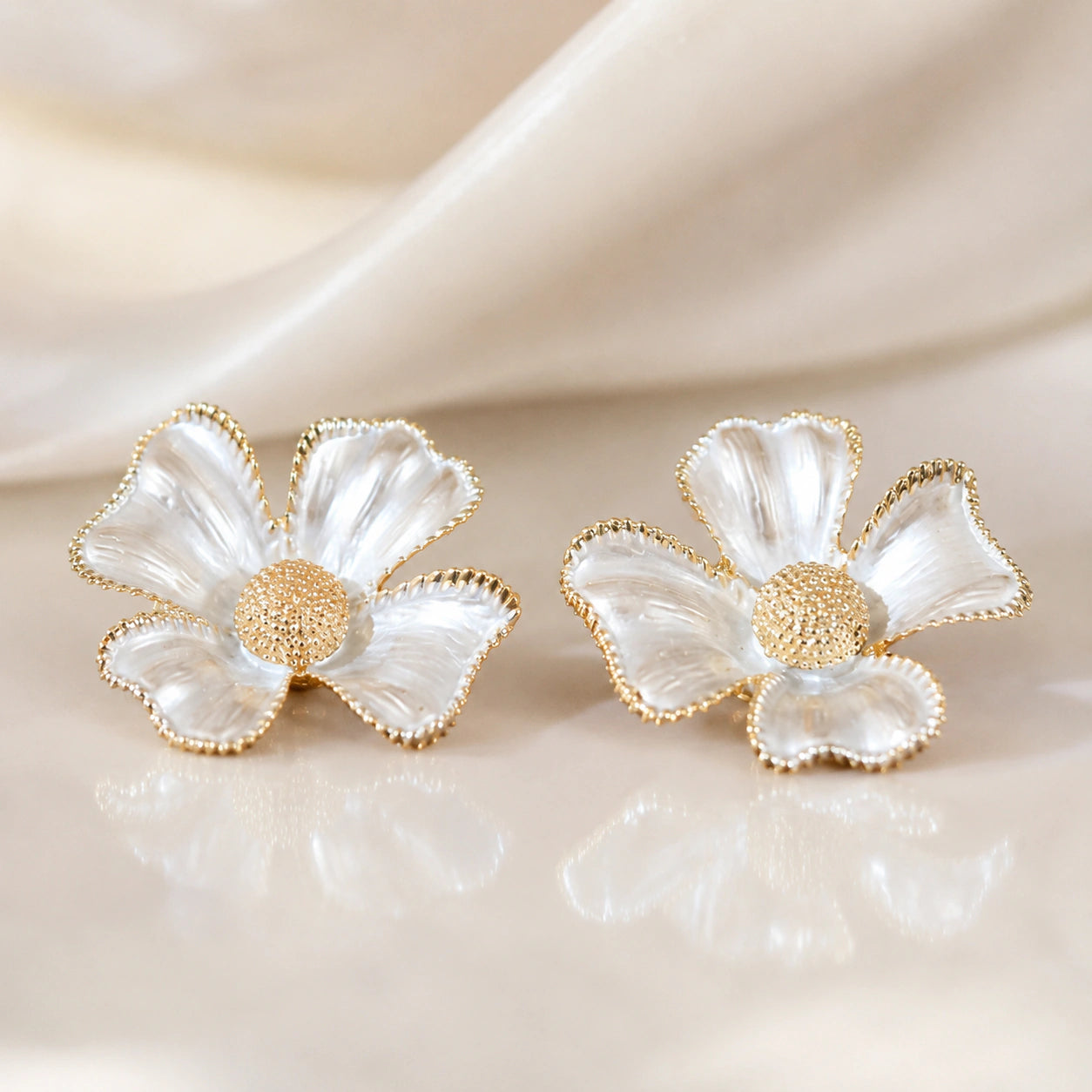 Pearl gold floral earrings styled in a modern jewellery flat lay