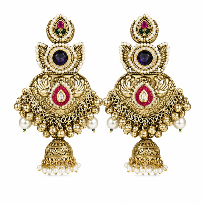 Angled view of gold-tone Kundan-style jhumka earrings with layered pearl details