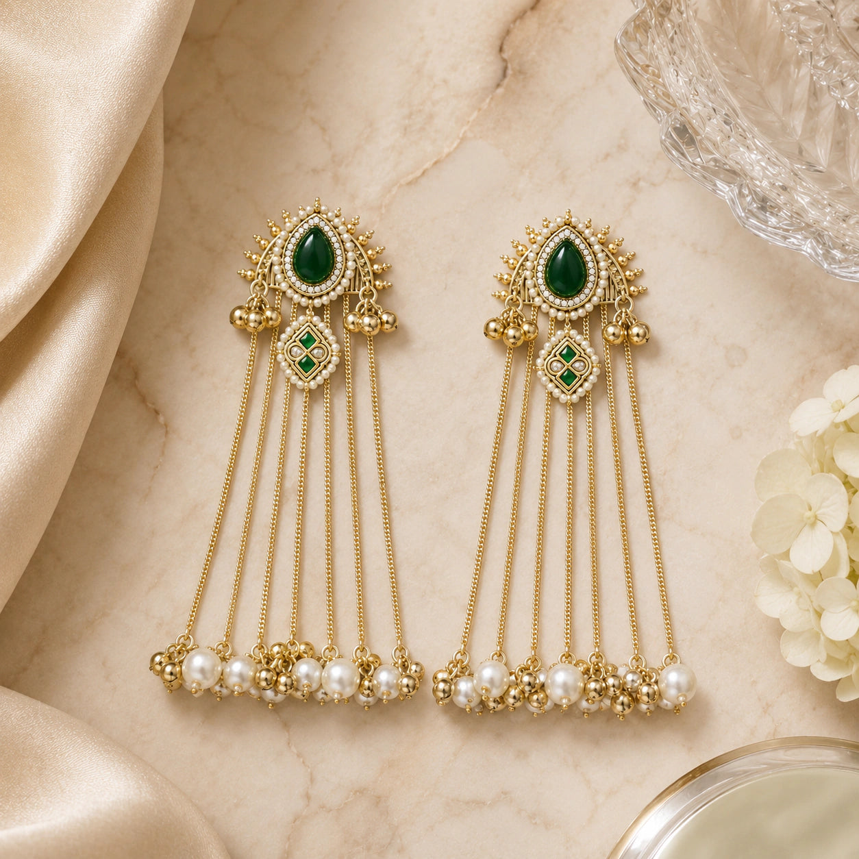 Gold-tone pearl tassel statement earrings styled in an elegant jewellery flat lay