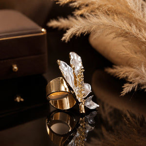 Pearl-white leaf vine ring styled in an elegant jewellery flat lay