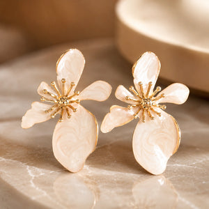 Angled view of pearl-white marbled floral gold-tone drop earrings