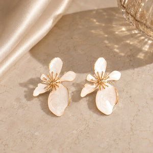 Pearl-white marbled floral earrings styled in an elegant jewellery flat lay
