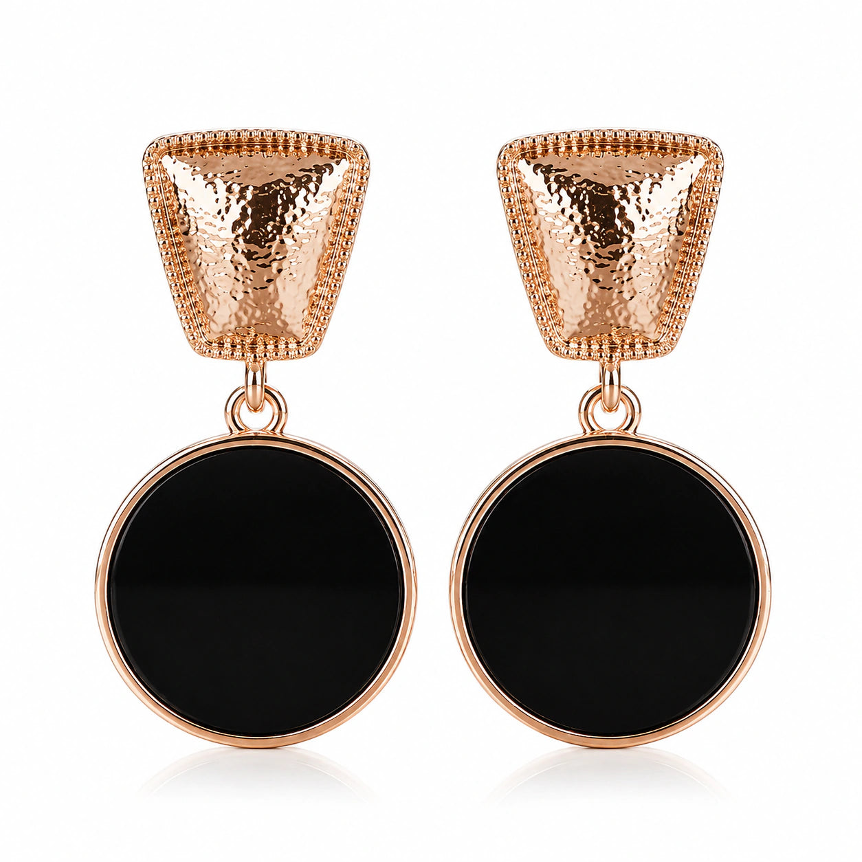Close-up of textured rose-gold tops and black disc pendants
