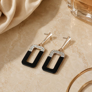 Rose-gold black geometric earrings styled in a modern jewellery flat lay