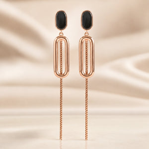 Rose-gold black oval-chain earrings styled in an elegant jewellery flat lay