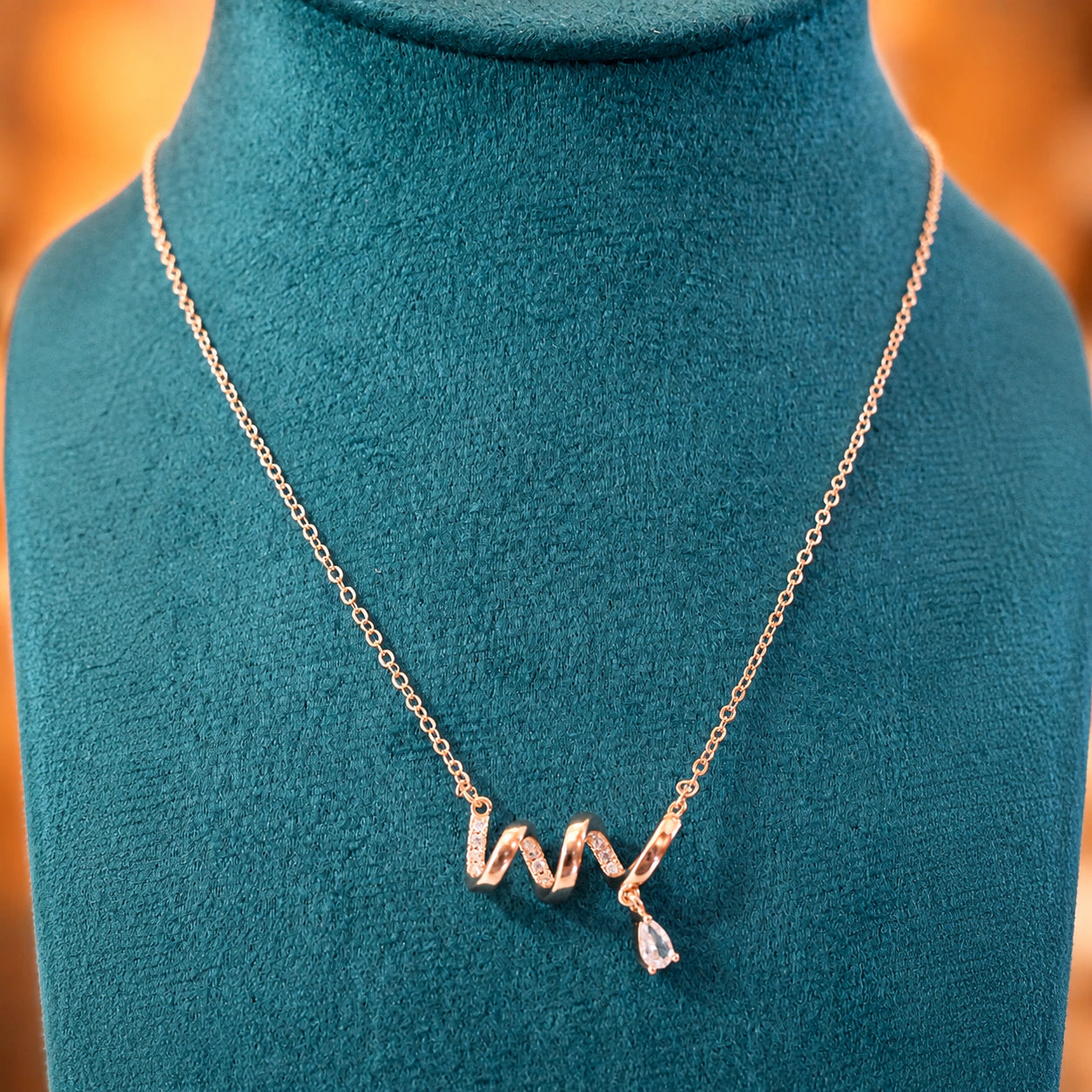 Alternate detail view of the rose-gold crystal wave pendant