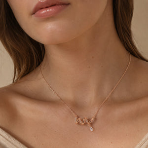 Rose-gold crystal wave necklace styled in an elegant jewellery flat lay