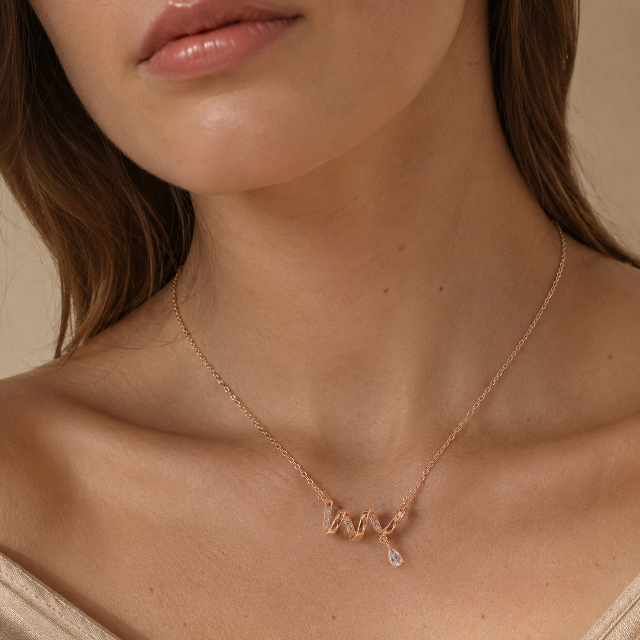 Rose-gold crystal wave necklace styled in an elegant jewellery flat lay