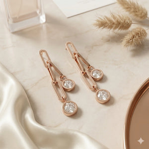 Rose-gold paperclip earrings styled in an elegant jewellery flat lay
