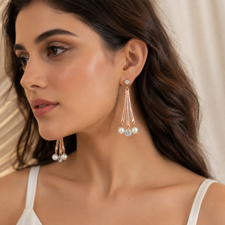 Rose-gold pearl crystal chandelier earrings on a dark jewellery studio display