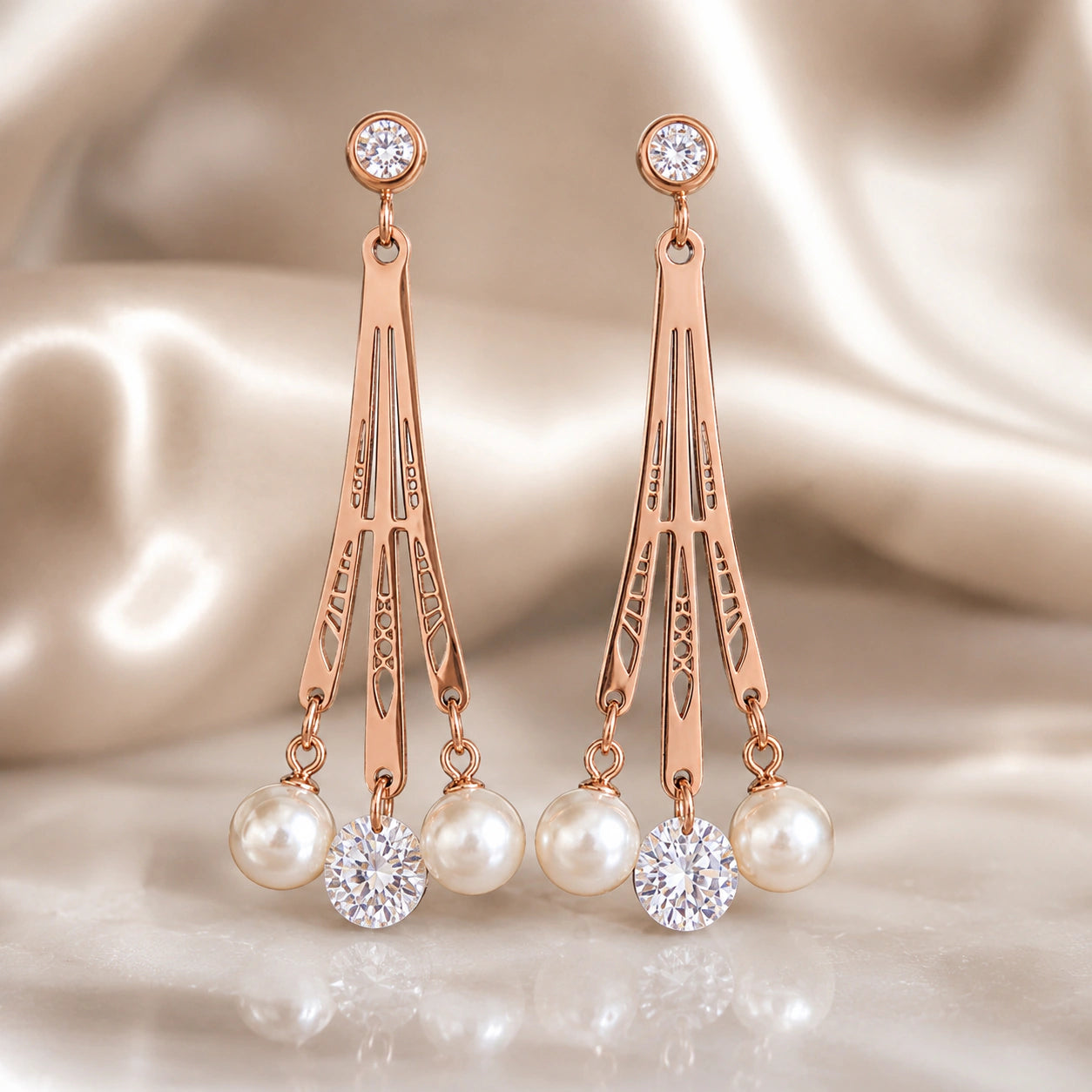 Rose-gold pearl chandelier earrings styled in an elegant jewellery flat lay
