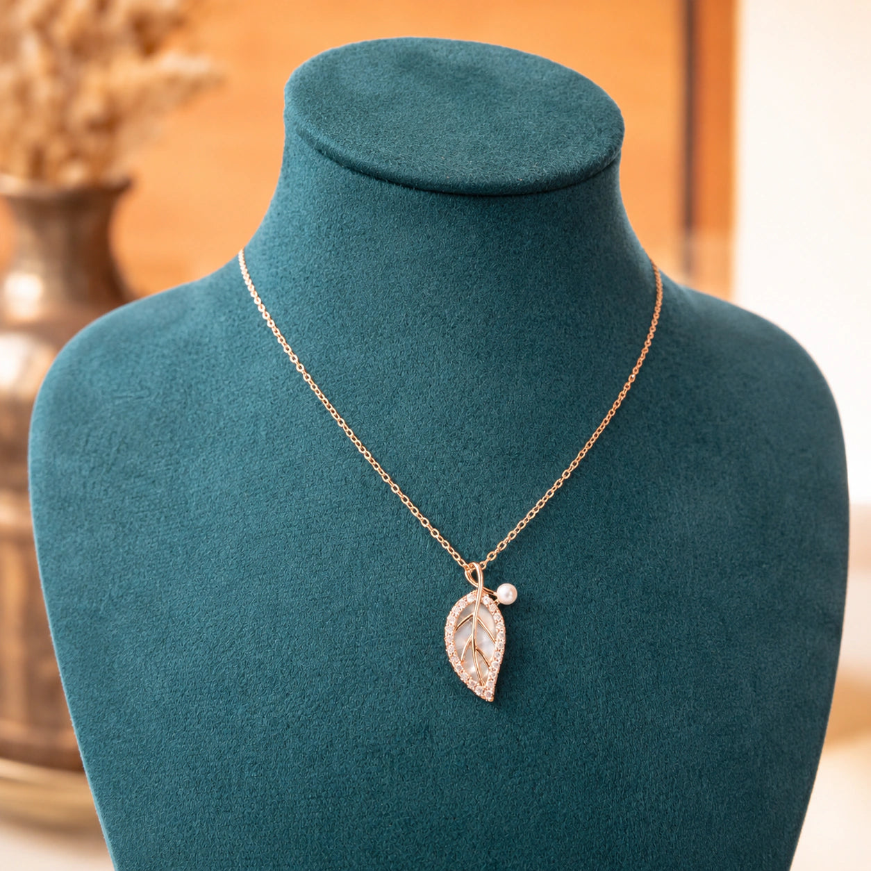 Rose-gold pearl leaf necklace styled in an elegant jewellery flat lay
