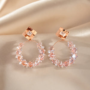 Rose-gold square crystal hoop earrings styled in an elegant jewellery flat lay