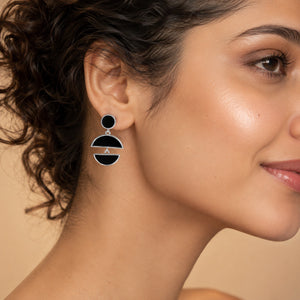 Silver black floral pearl hoops on a dark jewellery studio display