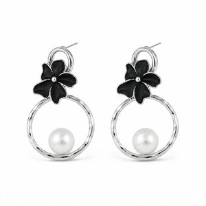 Close-up of black floral elements, silver hoops and pearl-style detailing