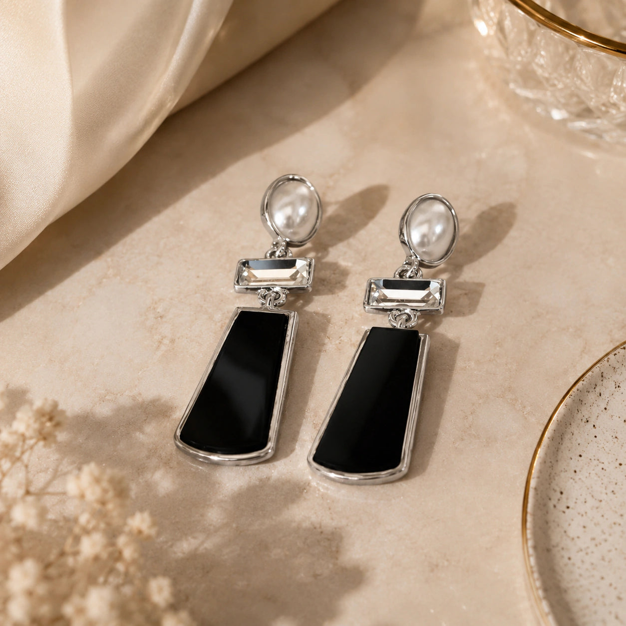 Angled view of silver black pearl crystal dangle earrings
