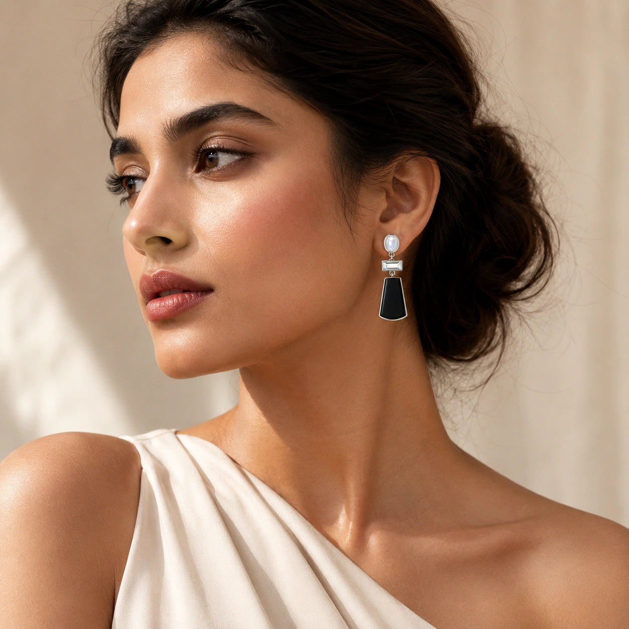 Silver black pearl crystal earrings on a dark jewellery studio display