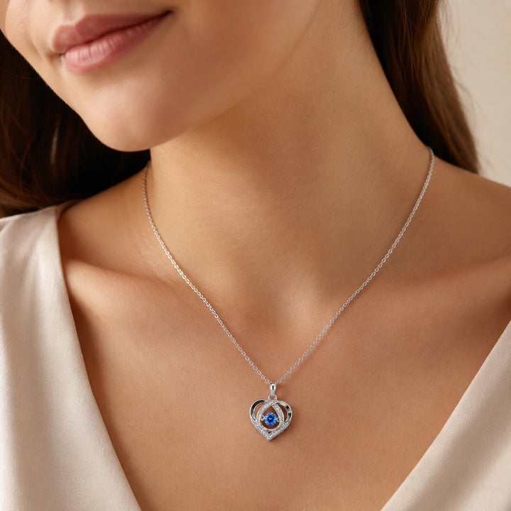 Silver blue crystal heart necklace on a dark jewellery studio display