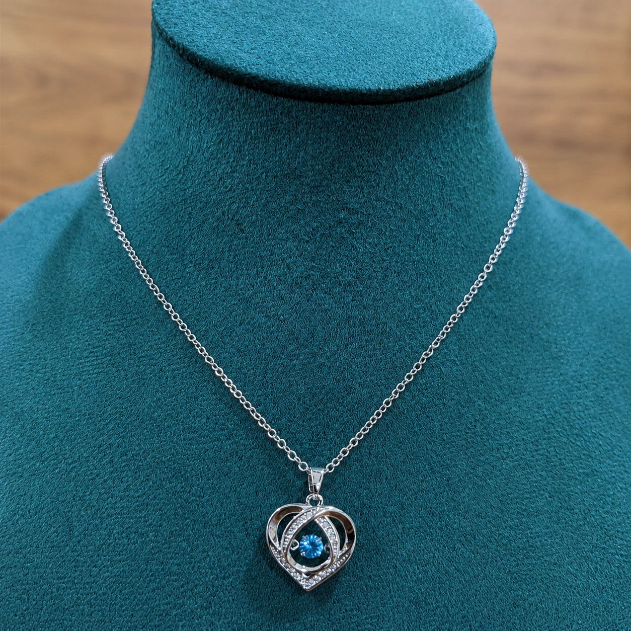 Silver blue heart necklace styled in an elegant jewellery flat lay