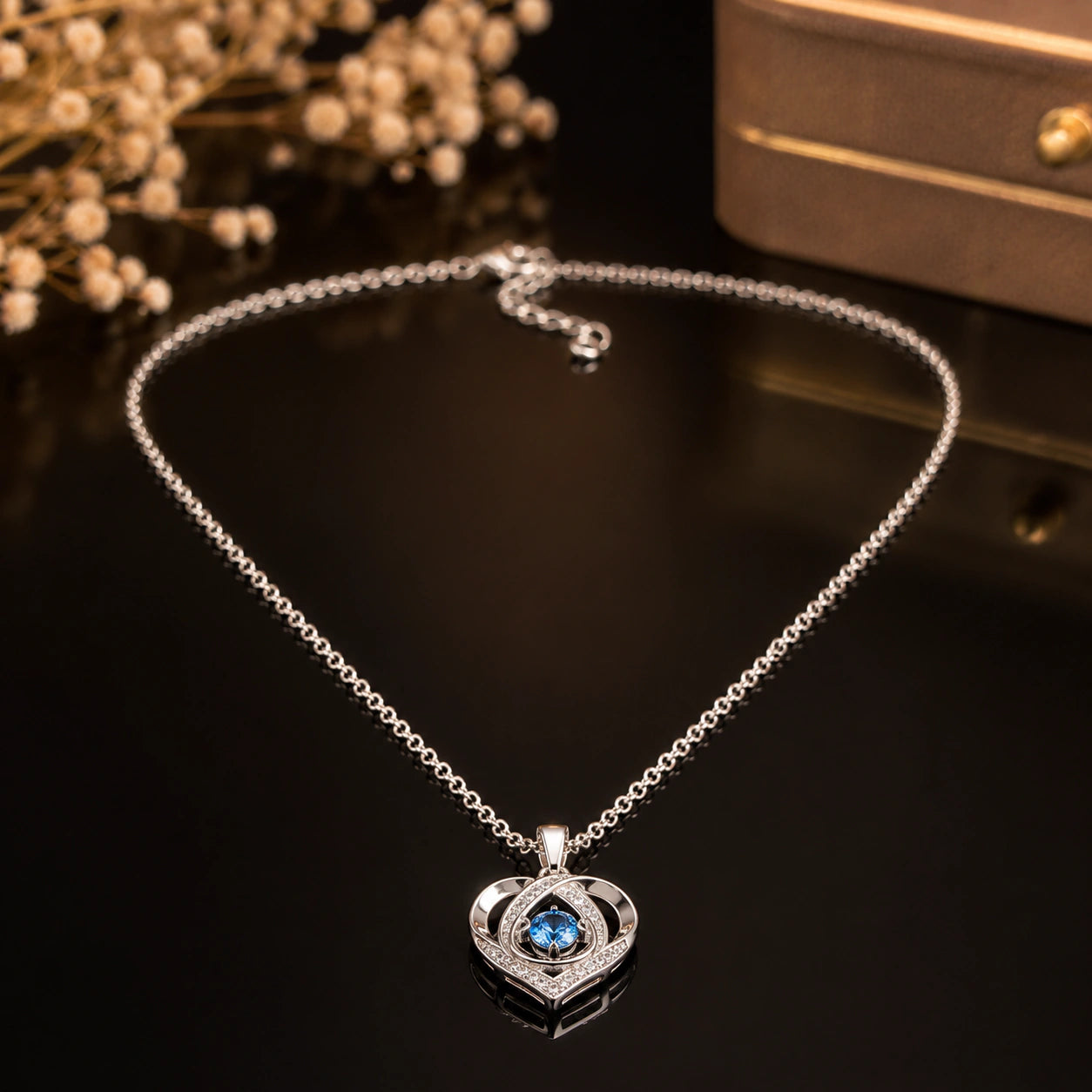 Close-up of the blue crystal-style heart pendant detailing