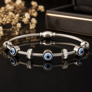 Angled view of the silver evil-eye crystal charm bracelet