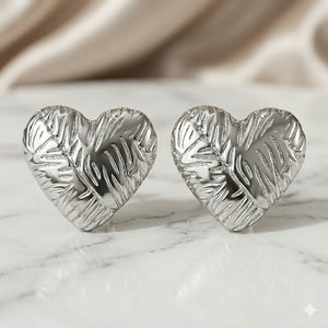 Silver leaf relief heart studs styled in an elegant jewellery flat lay