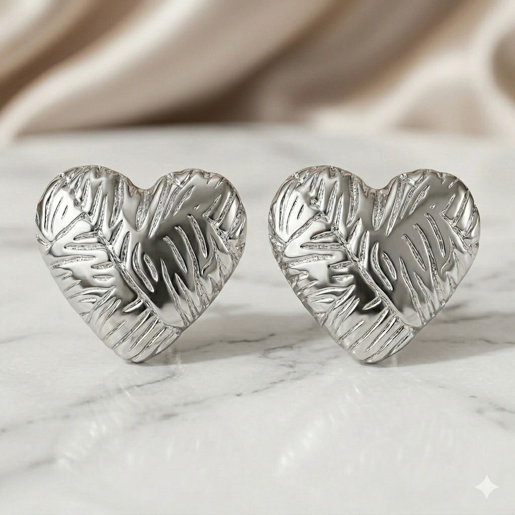 Silver leaf relief heart studs styled in an elegant jewellery flat lay