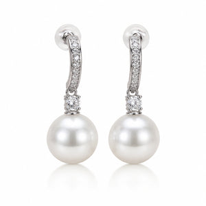 Silver pearl crystal-style drop earrings styled in an elegant jewellery flat lay