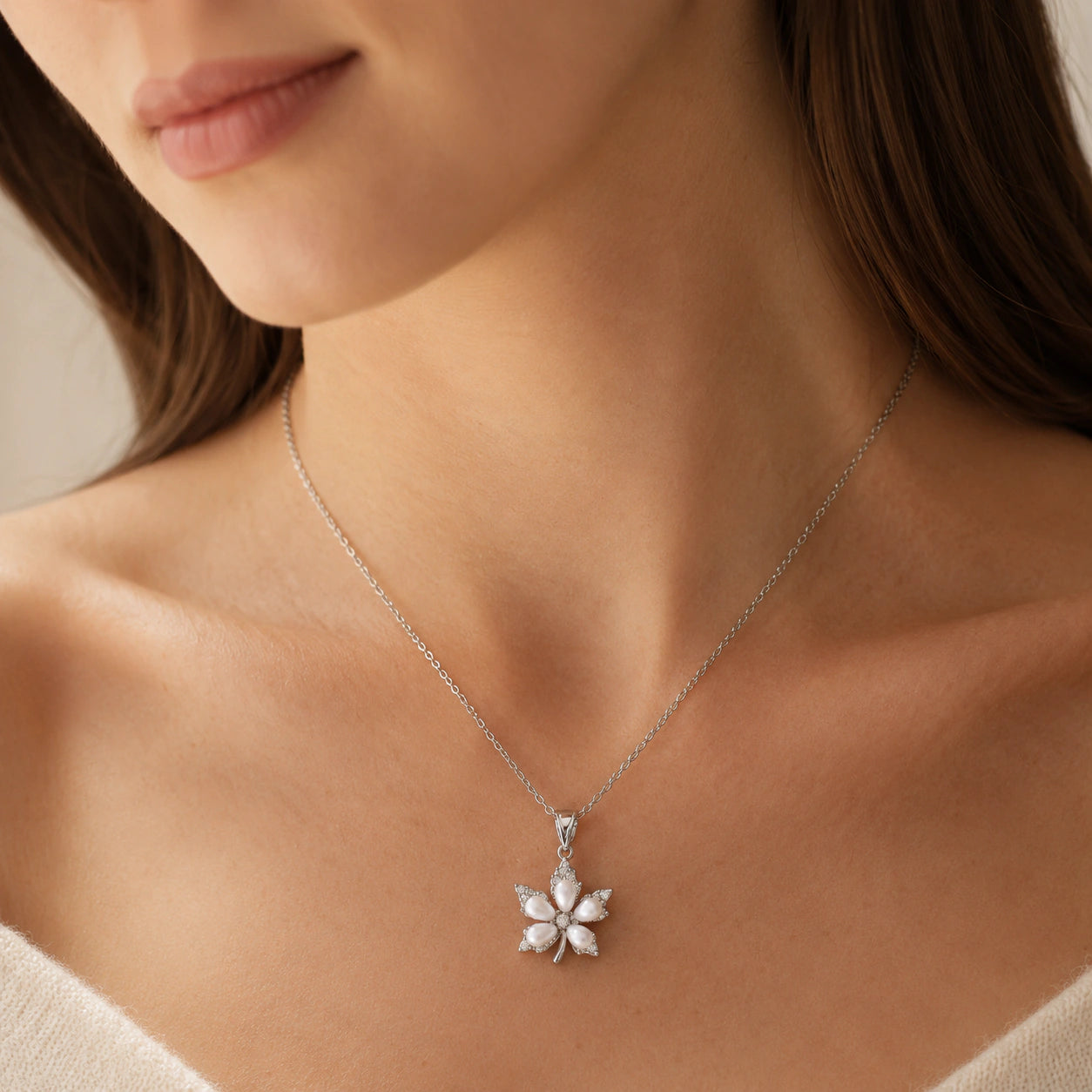Silver pearl floral necklace on a dark jewellery studio display