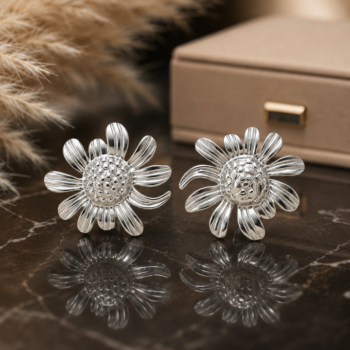 Silver ribbed daisy stud earrings with textured centre