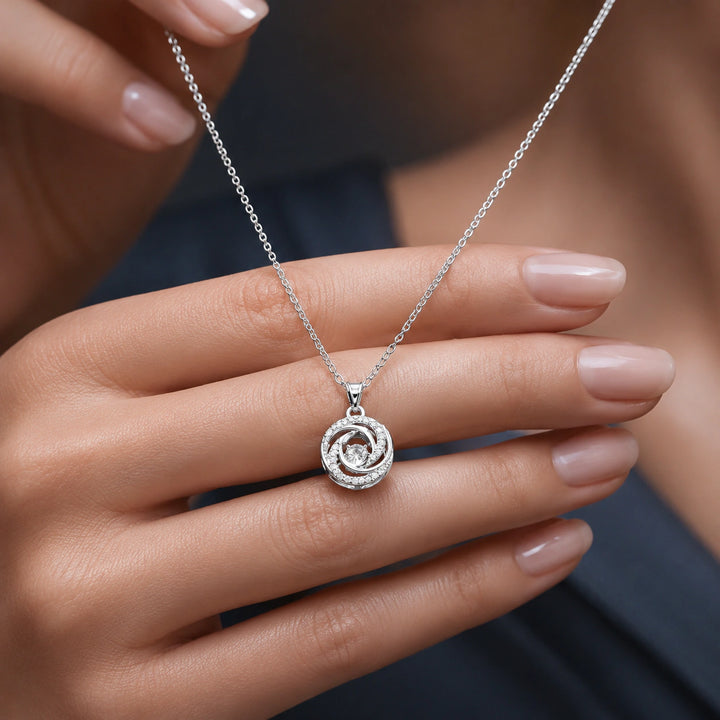 Silver spiral bloom pendant necklace on a dark jewellery studio display
