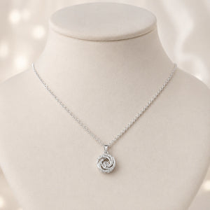 Silver spiral bloom necklace styled in an elegant jewellery flat lay